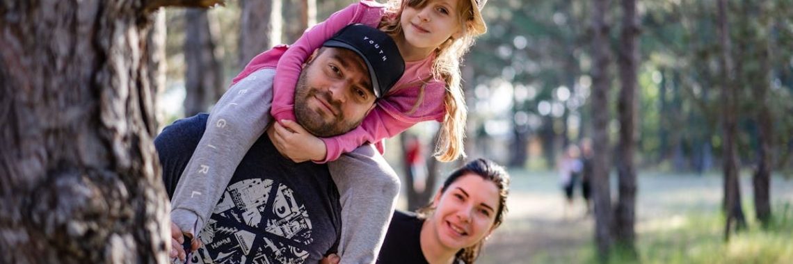 A joyful family enjoying a playful day in a sunlit forest park, capturing the essence of togetherness.